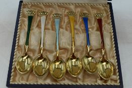 A cased set of six gold plated Danish silver coffee spoons having multi coloured enamel decoration