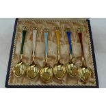 A cased set of six gold plated Danish silver coffee spoons having multi coloured enamel decoration