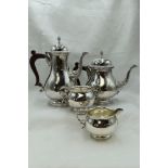 A modern silver four piece tea set of plain form with gadrooned circular pedestals, pineapple