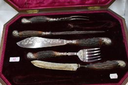 A cased Victorian seven piece carving set, missing 2 pieces having antler horn handles with silver