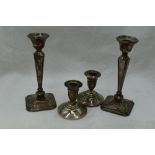 A pair of silver candlesticks having tapered columns to canted square weighted bases, Birmingham