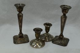 A pair of silver candlesticks having tapered columns to canted square weighted bases, Birmingham