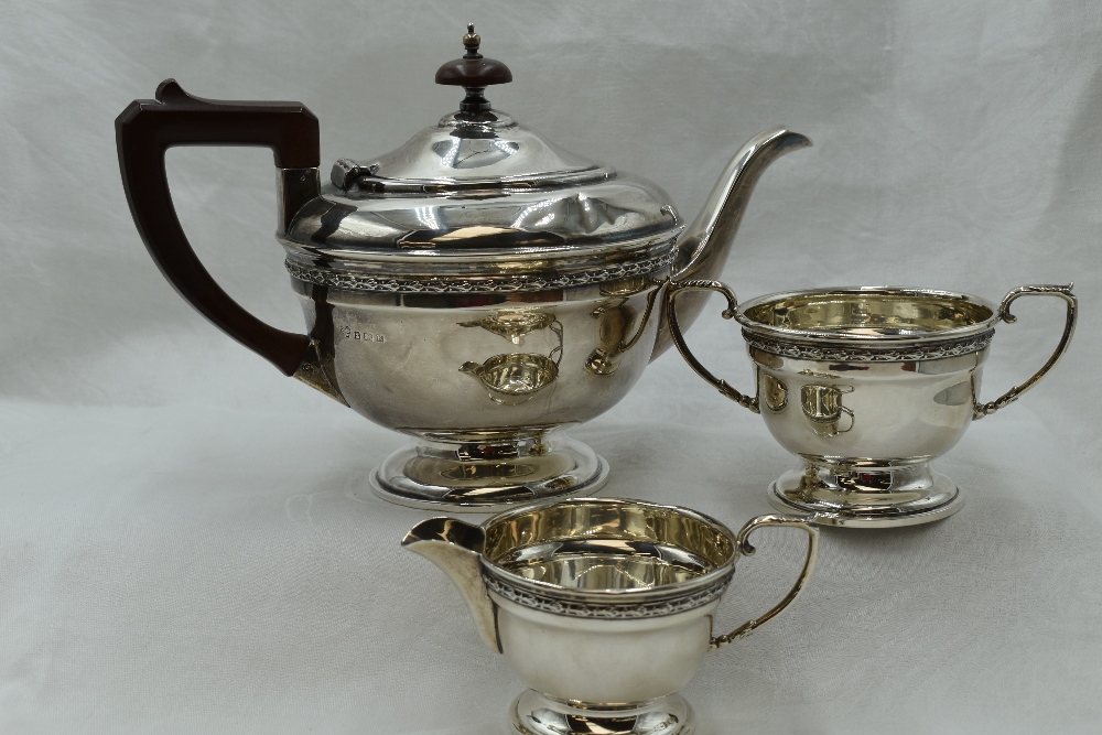 A silver three piece breakfast set of plain circular form having fruit wood handle, and ribbon