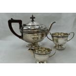 A silver three piece breakfast set of plain circular form having fruit wood handle, and ribbon