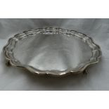 A silver salver of plain form having pie crust rim and quatrefoil ball and claw feet, Sheffield