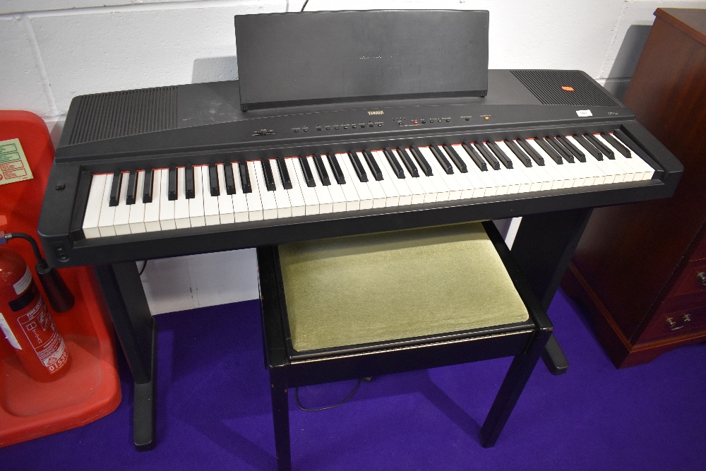 A Yamaha YPP-55 digital piano on integral stand, stool and small selection of sheet music books