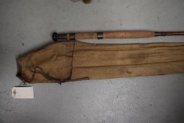 A vintage cane fishing rod approx 11ft unmarked with sleeve