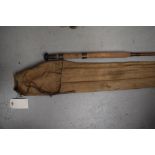 A vintage cane fishing rod approx 11ft unmarked with sleeve