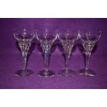 A set of four small vintage glasses, having colourful twisted stems.