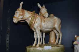 A Royal Dux figural group study of two donkeys stamped with lozenge to base (damage to one ear)