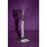 A cordial glass with moulded decoration to the bowl over stem with an opaque multi twist spiral at