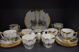 A stunning Shelley 'Sunrise and tall trees' part tea set comprising of eight Queen Anne shaped cups,