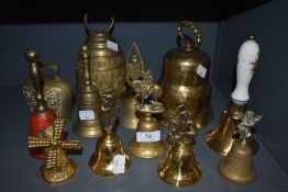 A selection of vintage brass bells, including cow bells and souvenir types. One having red enamel