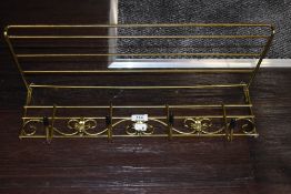 A Mid century brass coat rack with shelf.