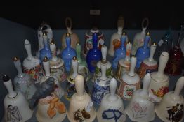A large collection of ceramic and similar bells, various patterns and designs.