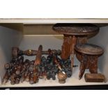 An assortment of wooden items including carved Indian styled tables and a huge array of finials or