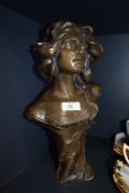 A bronze effect figural bust of a lady having Art Nouveau styled design
