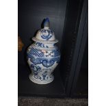 An early 20th century blue and white lidded jar of bulbous style, having band and pictorial