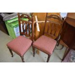 A pair of Victorian dining chairs having overstuffed seats