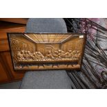 A metal plaque, bronzed effect, depicting last supper (eat out to help out?)