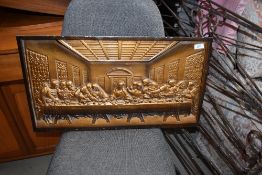 A metal plaque, bronzed effect, depicting last supper (eat out to help out?)