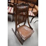 A Victorian oak rail back rocking chair, with leather seat and shoulder support