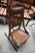 A Victorian oak rail back rocking chair, with leather seat and shoulder support