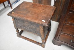 A traditional carved oak box stool of large proportions, having carved panel decoration, approx
