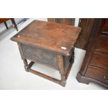 A traditional carved oak box stool of large proportions, having carved panel decoration, approx