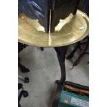 An Oriental or Islamic brass tray top table, having dark fretwork frame