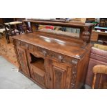 A Victorian oak sideboard, having carved panel and mask handles and mirrored ledge back, width