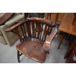 A late 19th/early 20th Century oak comb back smokers bow style carver chair