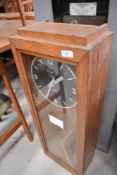 A vintage electro mechanical regulator clock, in oak and glazed case, black and chromed dial named