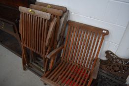 A set of four folding teak garden chairs