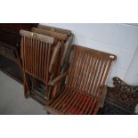 A set of four folding teak garden chairs