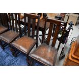 A set of four early 20th Century oak rail back dining chairs and drawer leaf dining table