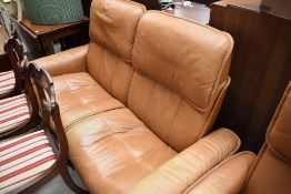 A tan leather stressless two seater settee