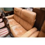 A tan leather stressless two seater settee