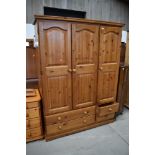 A modern pine triple wardrobe, Kenilworth farmhouse design, having drawer base, width approx. 140cm