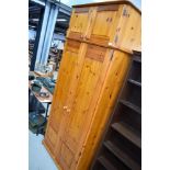 A modern pine wardrobe, with upper cupboard section