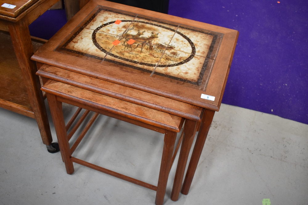 A vintage tile top nest of three tables