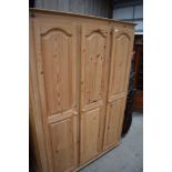 A modern triple wardrobe in natural pine, approx. width 135cm