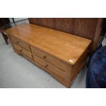 A modern light stained ottoman/bedding box having lift top and dummy drawer fronts, would also