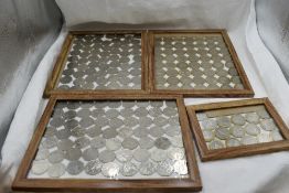 A collection of GB coins, fifty pence pieces and £2 pounds, in frames, fifty pences approximately