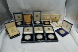 A collection of Ten Silver World Crown Sized Coins in cases