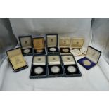 A collection of Ten Silver World Crown Sized Coins in cases