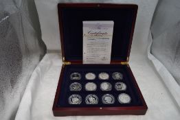 A collection of 12 Diamond Wedding Anniversary Silver Commonwealth crown sized coins, in fitted case