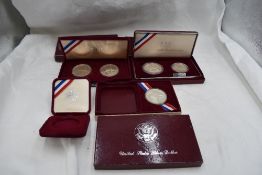 Three boxed sets of USA Olympic Silver Coins, 1984 Olympics x2 and 1992 Olympics, 5 coins in total