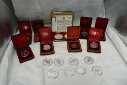 A collection of Silver Canadian Dollars, eight in plastic capsules, eight in cases along with two