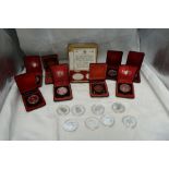 A collection of Silver Canadian Dollars, eight in plastic capsules, eight in cases along with two